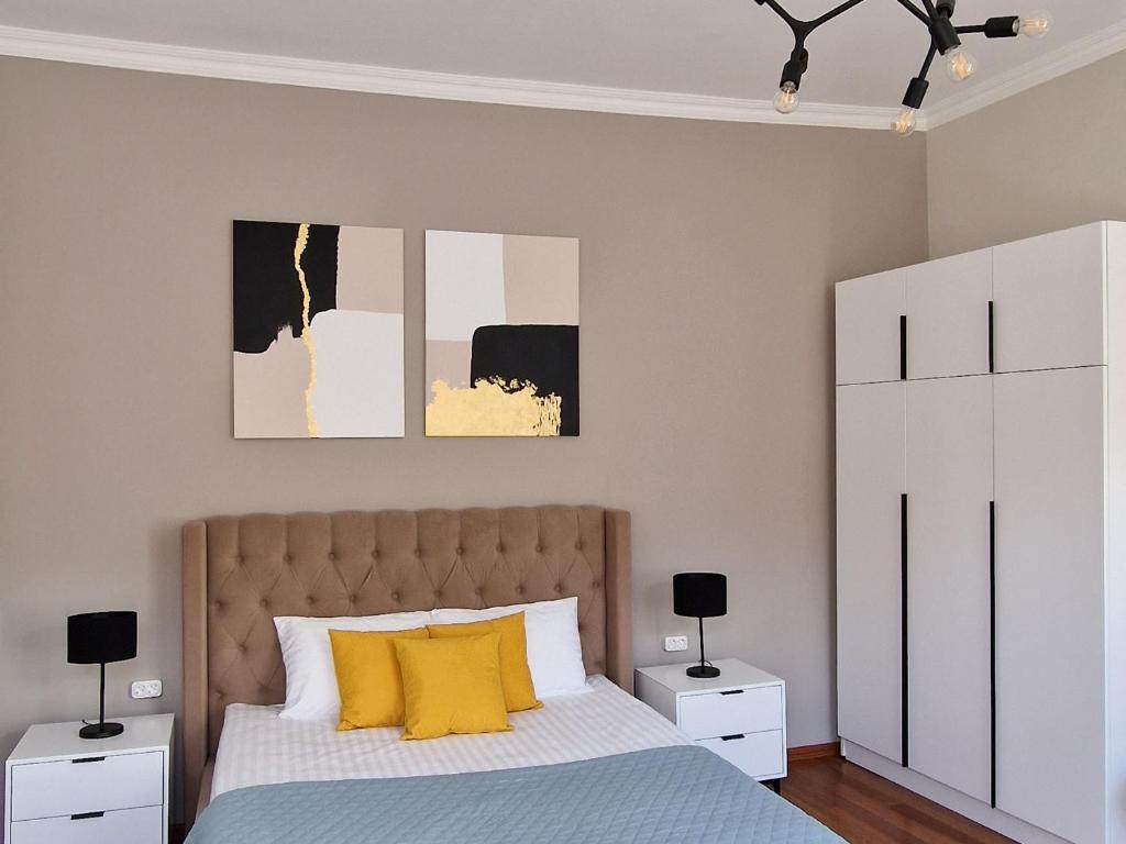 a bedroom with a bed with yellow pillows at SOPRANO APARTMENT KRAKIVSKA 34 in Lviv