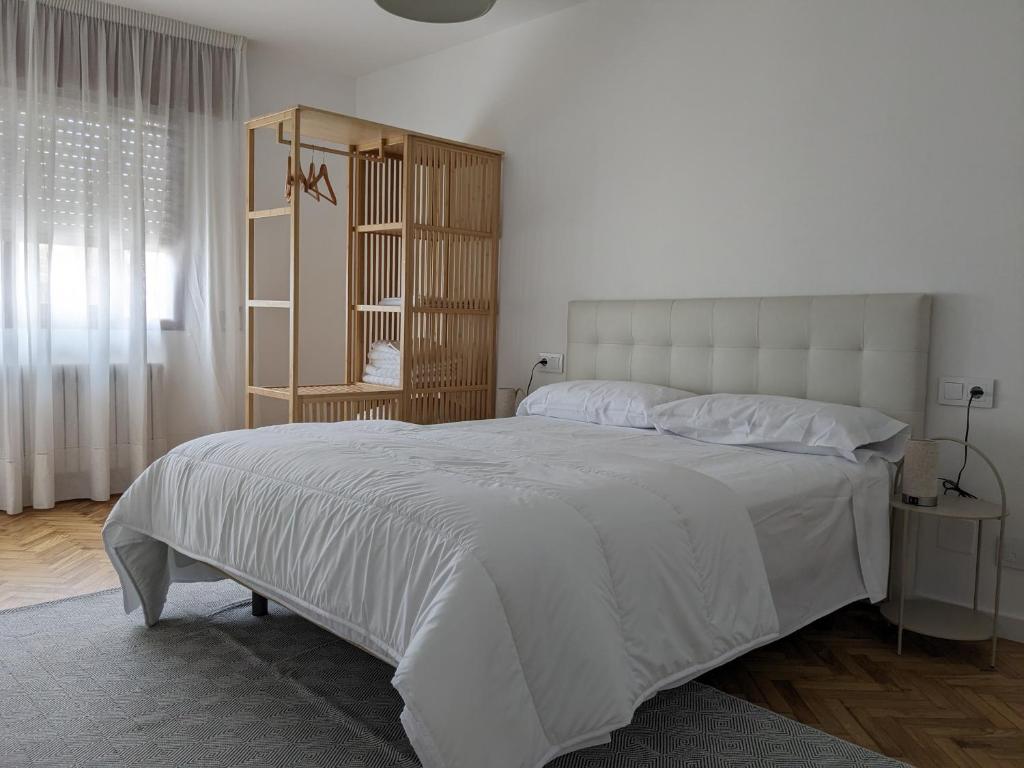 Un dormitorio con una gran cama blanca y una ventana en Mirador de Ferradores, en Betanzos