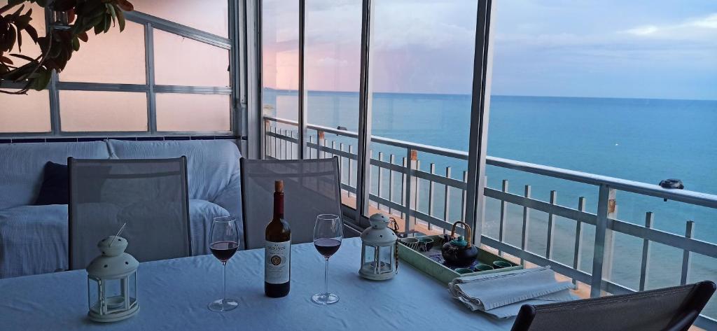 a table with wine bottles and glasses on a balcony at BLUE DOUBLE PRIVATE ROOM AT FRONT BEACH - HABITACION DOBLE en la playa in Valencia