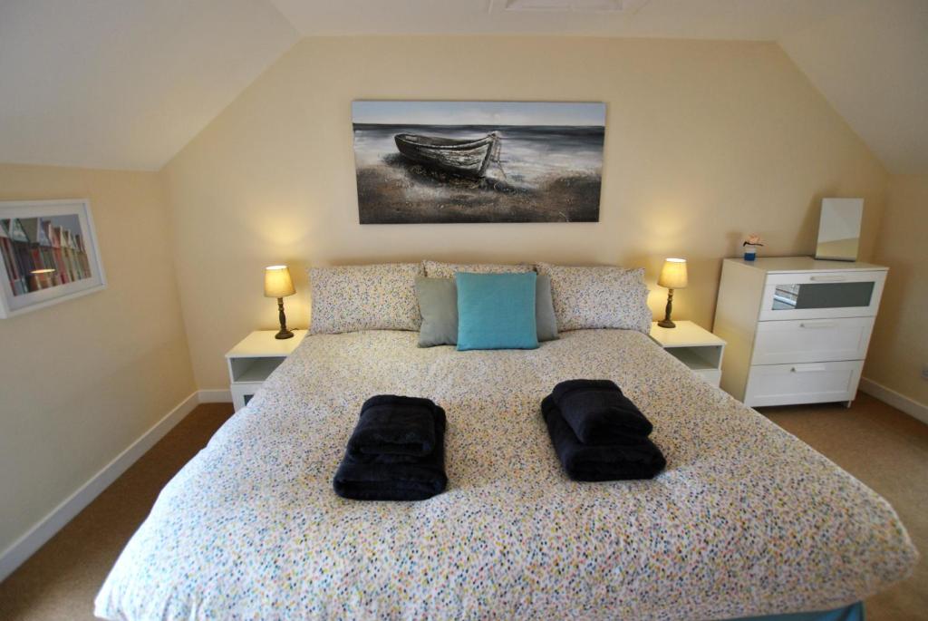 a bedroom with a bed with two black towels on it at Net Loft- homely accomodation in East Neuk in Anstruther