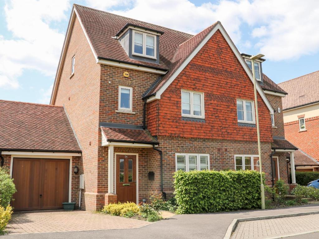 a red brick house with a wooden garage at Baldwin Close in Hook