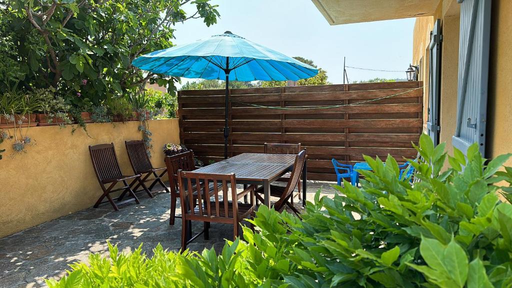 une table et des chaises avec un parasol sur une terrasse dans l'établissement Villa les Pensées La Londe, à La Londe-les-Maures