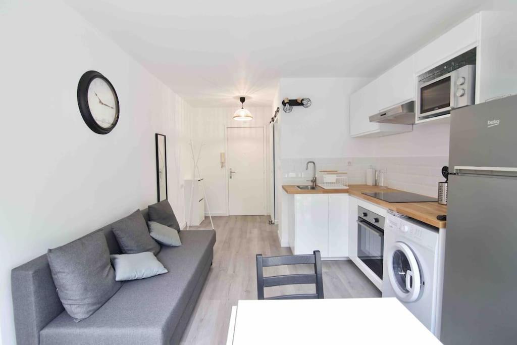 un salon avec un canapé et une cuisine dans l'établissement Le dyonisos et piscine, à La Seyne-sur-Mer