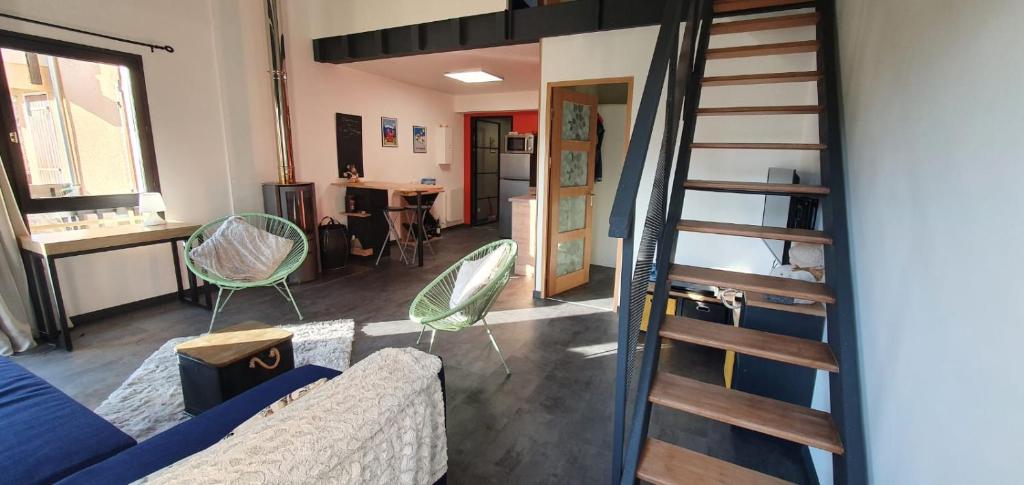 ein Wohnzimmer mit einem Sofa und einer Treppe in der Unterkunft Le 6 du Pitalugue in Ax-les-Thermes
