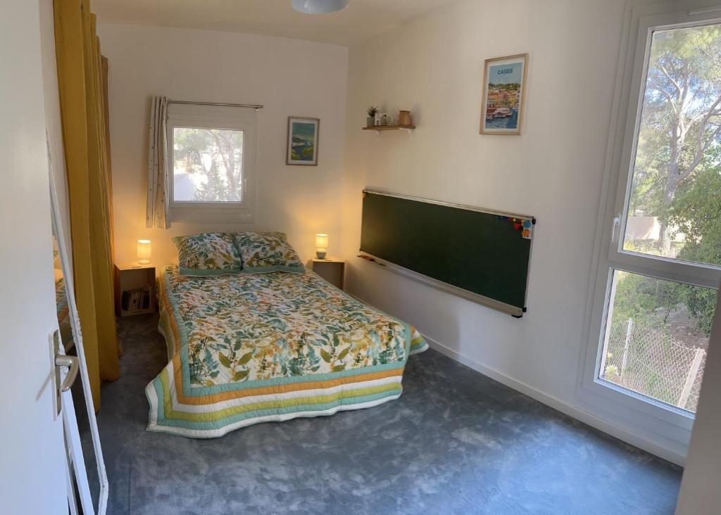 een slaapkamer met een bed en een flatscreen-tv bij Chambre double cassis in Cassis