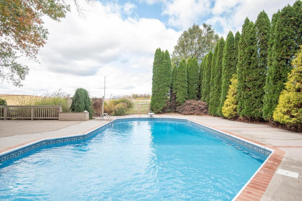 a swimming pool in a yard with trees at Cozy Cow in Gettysburg