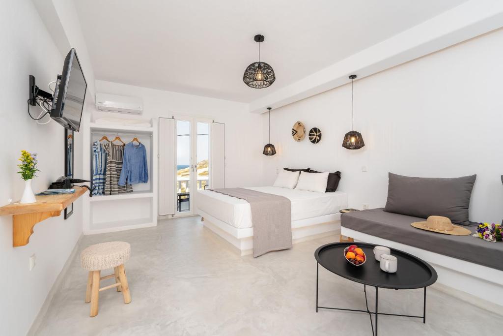 a bedroom with a bed and a table at Celestial Seaview Apartments-Portara in Naxos Chora