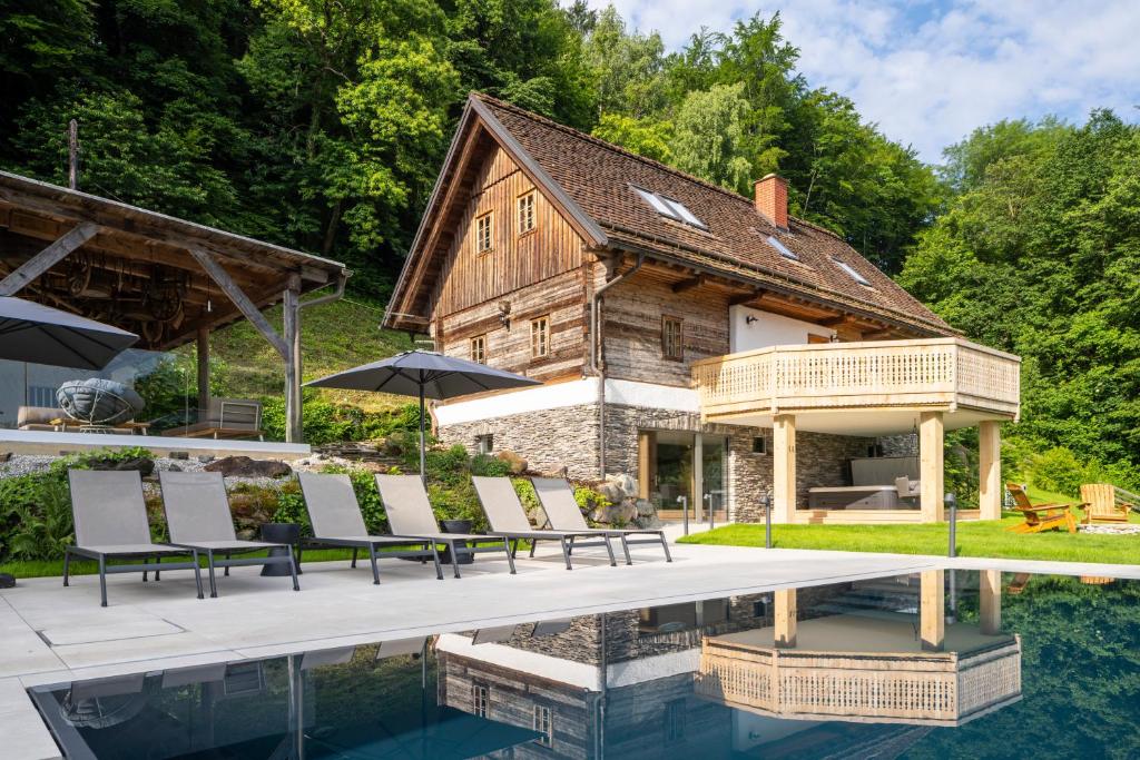 una casa con piscina y sillas junto a ella en steiRerBLiCke - Vinothek Petzles, en Sankt Nikolai im Sausal
