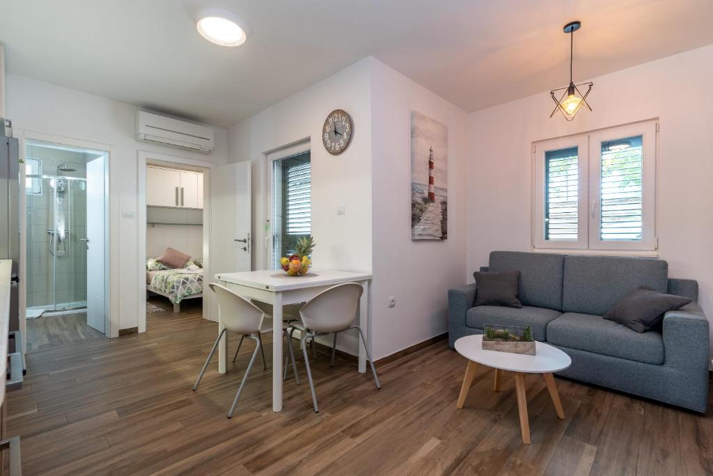 een woonkamer met een bank en een tafel bij Apartments Jurica in Trogir