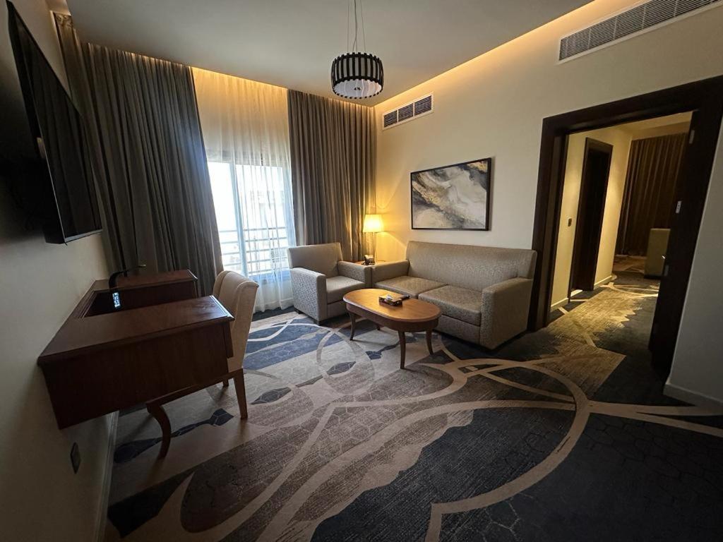 a living room with a couch and a piano at Hotel ALdoliaa in Unayzah