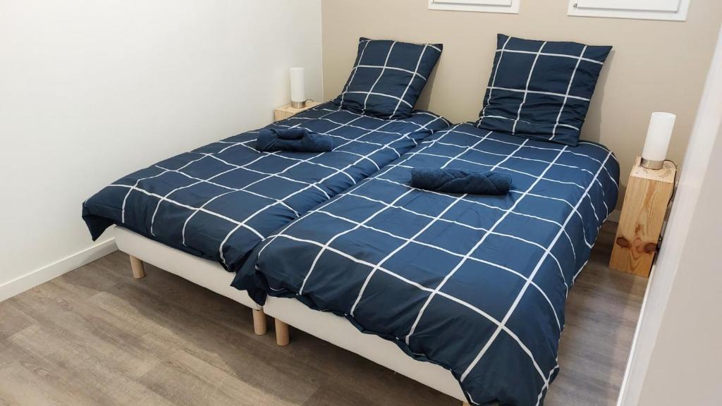 Un dormitorio con una cama azul con sábanas y almohadas azules en SER2 Studio , 2 lits simples, wifi, sweet home, en Saint-Étienne-du-Rouvray