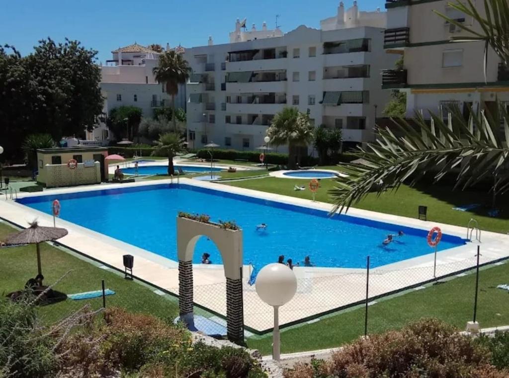 uma grande piscina em frente a alguns edifícios em Estudio con piscina a 200 m de la playa em Benalmadena Costa