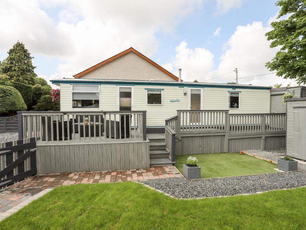 a house with a fence and a yard at Tyn Clwt in Caernarfon