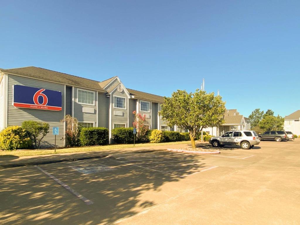 a building with a gmc sign in a parking lot at Studio 6 McAlester OK South in McAlester