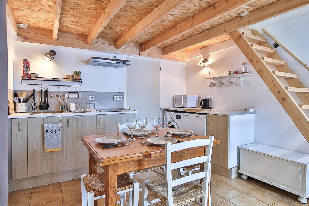 cocina y comedor con mesa de madera y sillas en Studio Le Petit Julien, en Saint-Julien-des-Landes