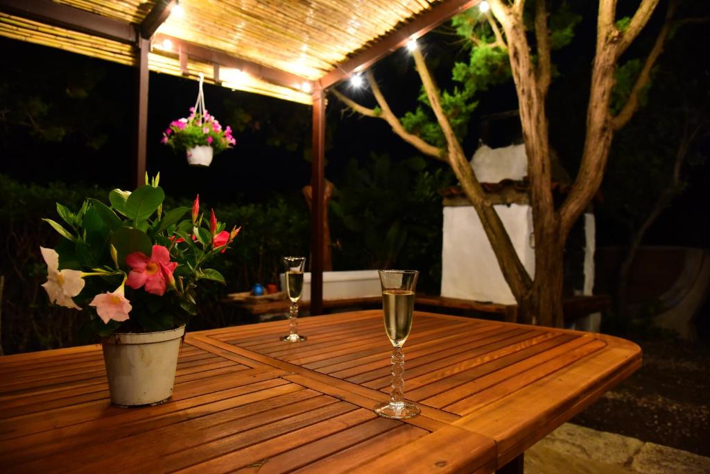 una mesa de madera con dos copas de vino. en Splendida villa in riva al mare, en Orosei