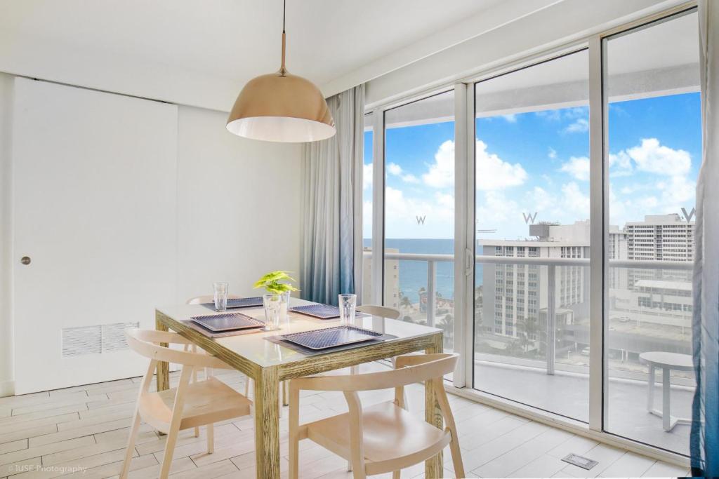 a dining room with a table and chairs and a large window at Luxury Well stocked SE Corner 2BR W Fort Lauderdale w Great Ocean Views in Fort Lauderdale