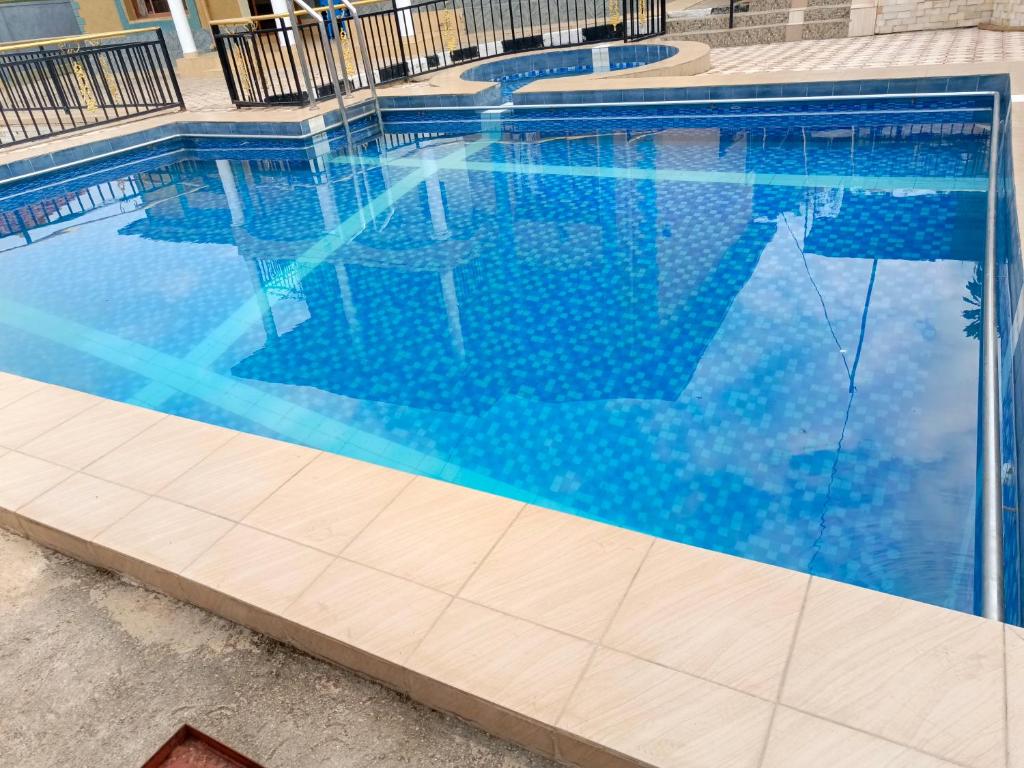Kigali Peace villa في كيغالي: مسبح بمياه زرقاء في مبنى