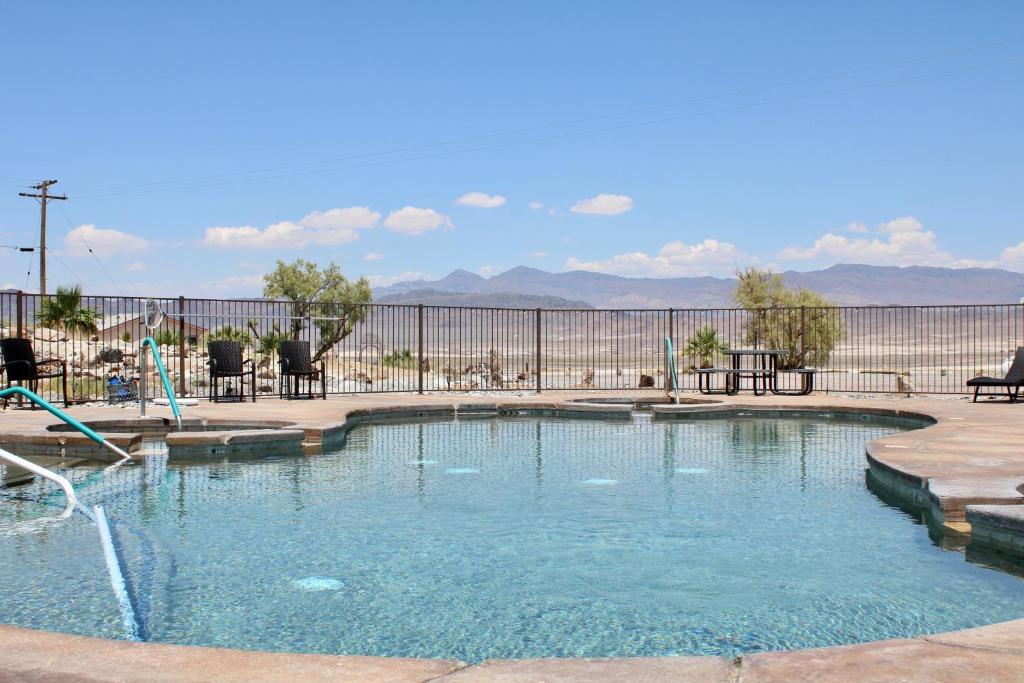 einem Pool mit Wasserrutsche vor einem Zaun in der Unterkunft Death Valley Hot Springs 1 Bedroom in Tecopa