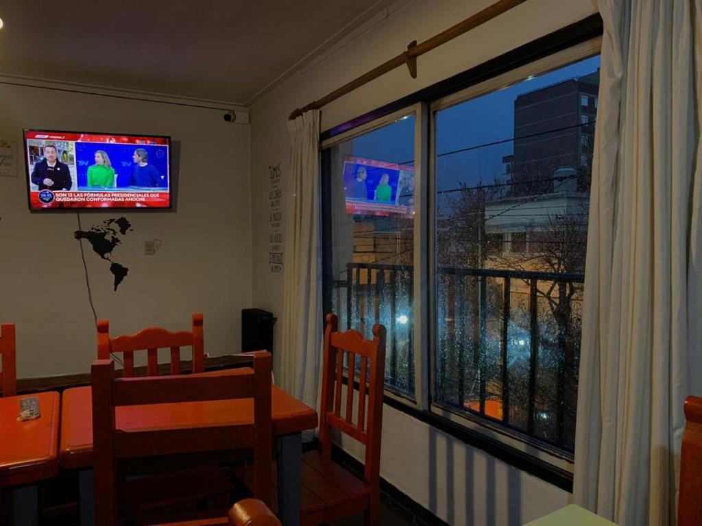 een eetkamer met een tafel en een groot raam bij Il Point Hostel Cafe in Neuquén
