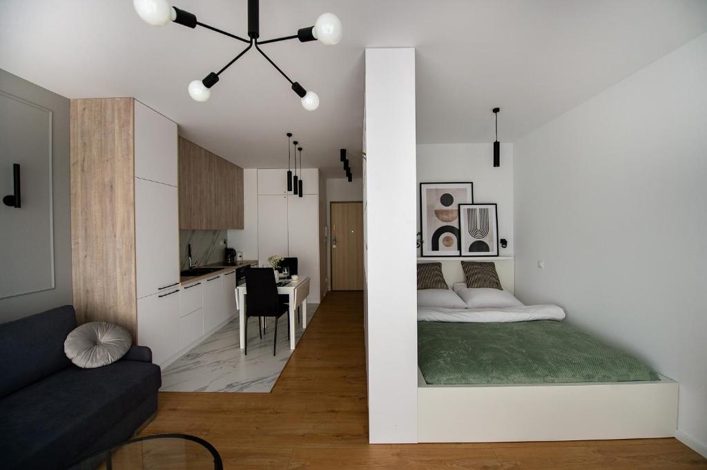 sypialnia oraz salon z łóżkiem i kuchnią w obiekcie EXCLUSIVE Apartamenty Lotnicza , PARKING w Kielcach