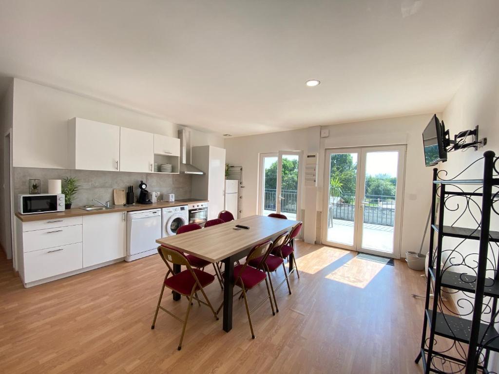 eine Küche und ein Esszimmer mit Tisch und Stühlen in der Unterkunft Appartement 10pers. à Vallères in Vallères