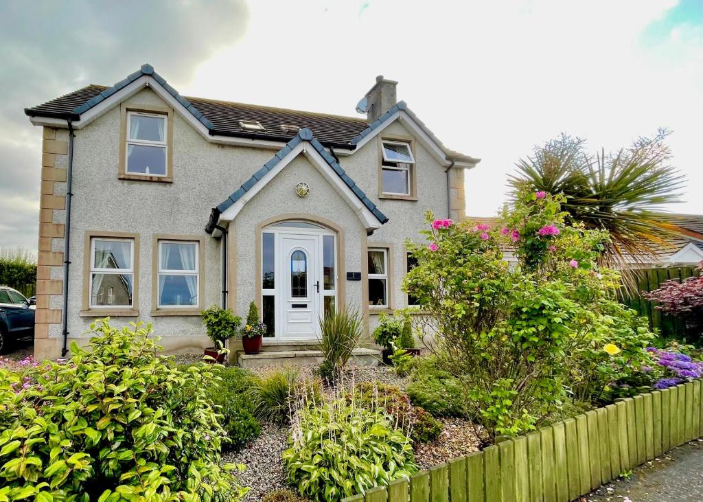 a house with a garden in front of it at Mount Edwards Hill Guest Accommodation in Cushendall