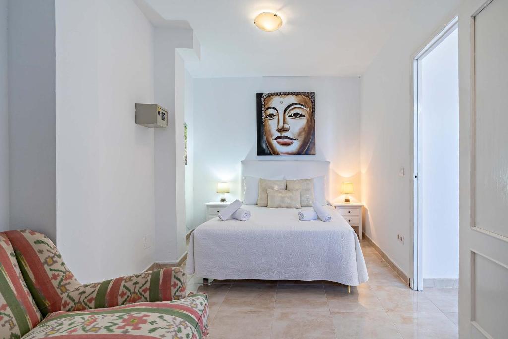 a bedroom with a bed with a painting on the wall at Apartamentos Dulcemar Frente al Mar con zona SPA in San José