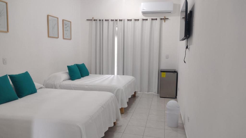 Habitación con 2 camas y TV de pantalla plana. en Casa Tauch, en Cancún
