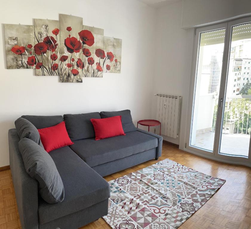 ein Wohnzimmer mit einem grauen Sofa und roten Kissen in der Unterkunft CASA DENDI in Triest