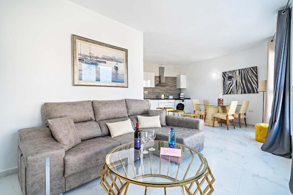 a living room with a couch and a glass table at Apartamentos Dulcemar Frente al Mar con zona SPA in San José