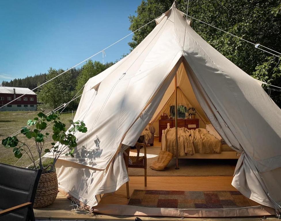duży biały namiot z łóżkiem w obiekcie Idyllisk glamping rett ved elven w mieście Skien