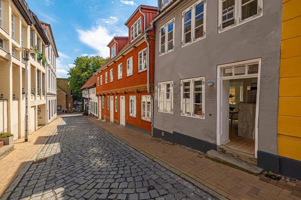 a cobblestone street in a town with colorful buildings at Luettje Huus in Flensburg