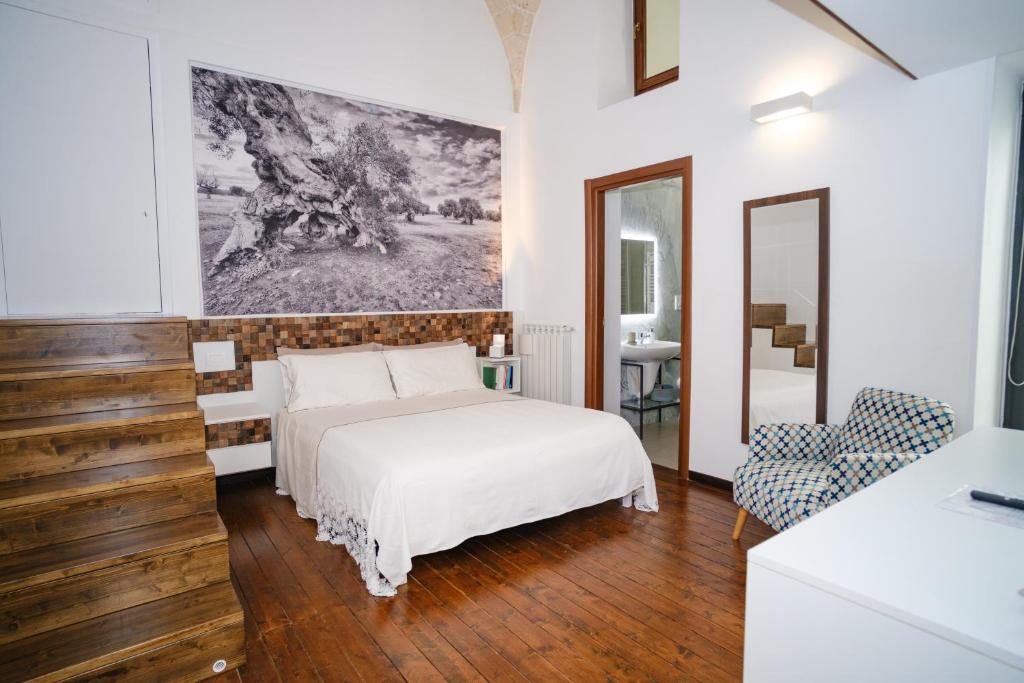 a white bedroom with a bed and a mirror at Welcome Ostuni b&b in Ostuni
