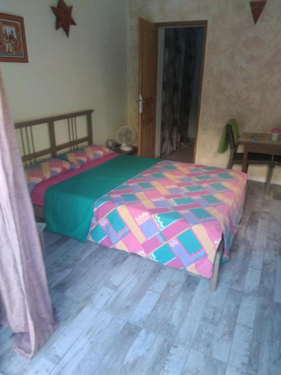sypialnia z łóżkiem z kolorową kołdrą w obiekcie Anemones w mieście Castelnau-le-Lez