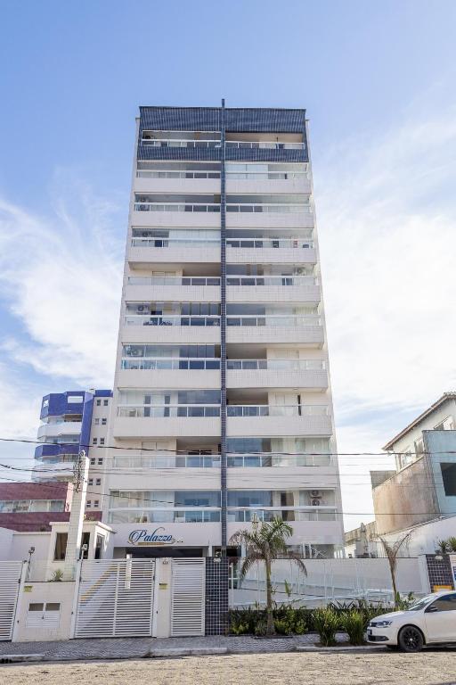 a tall building with a car parked in front of it at Itanhaém Praia & Mar in Itanhaém
