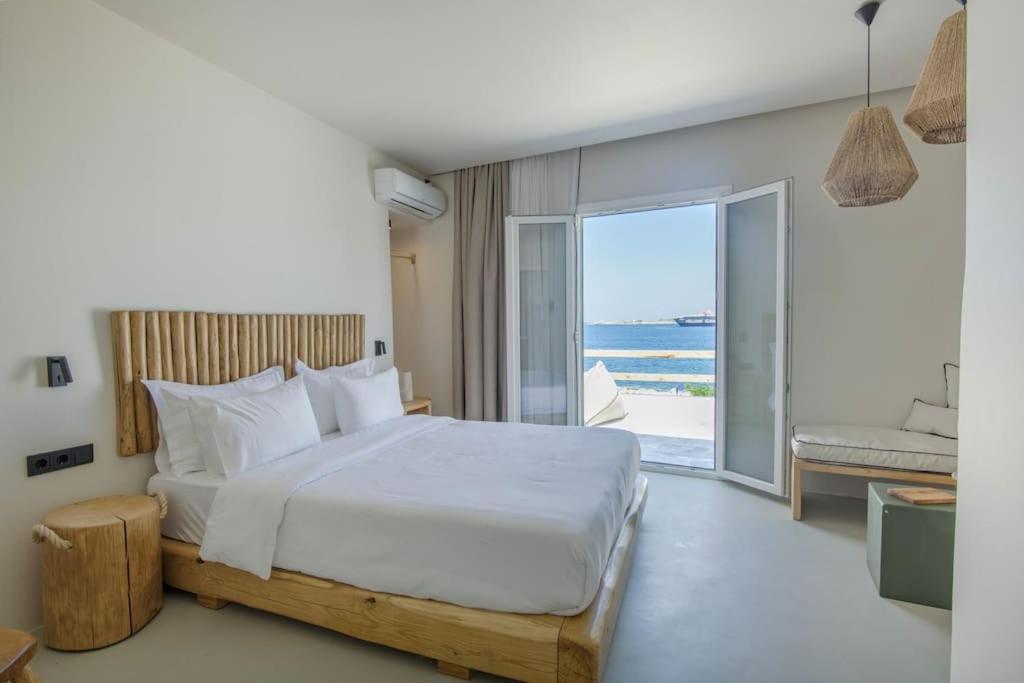 a bedroom with a bed and a view of the ocean at Lyra Sunset Suite in Kampos Paros