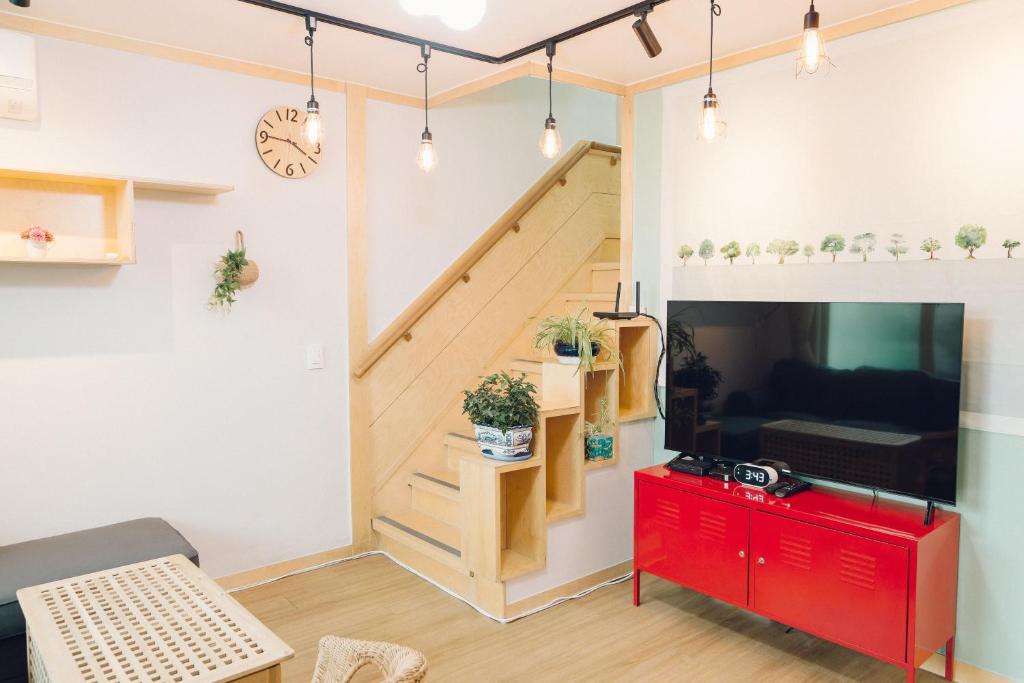 um quarto com uma escada e uma sala de estar com uma televisão em Hongdae Luxury Private Single House with Big Open Balcony Perfect for a Family & Big Group 3BR, 5QB & 1SB, 2Toilet em Seul