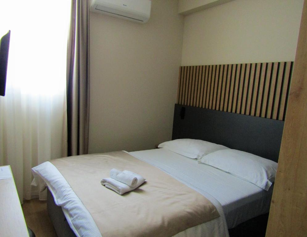 ein Schlafzimmer mit einem Bett mit zwei Handtüchern darauf in der Unterkunft Beach Hotel Božikovina 2 in Podstrana