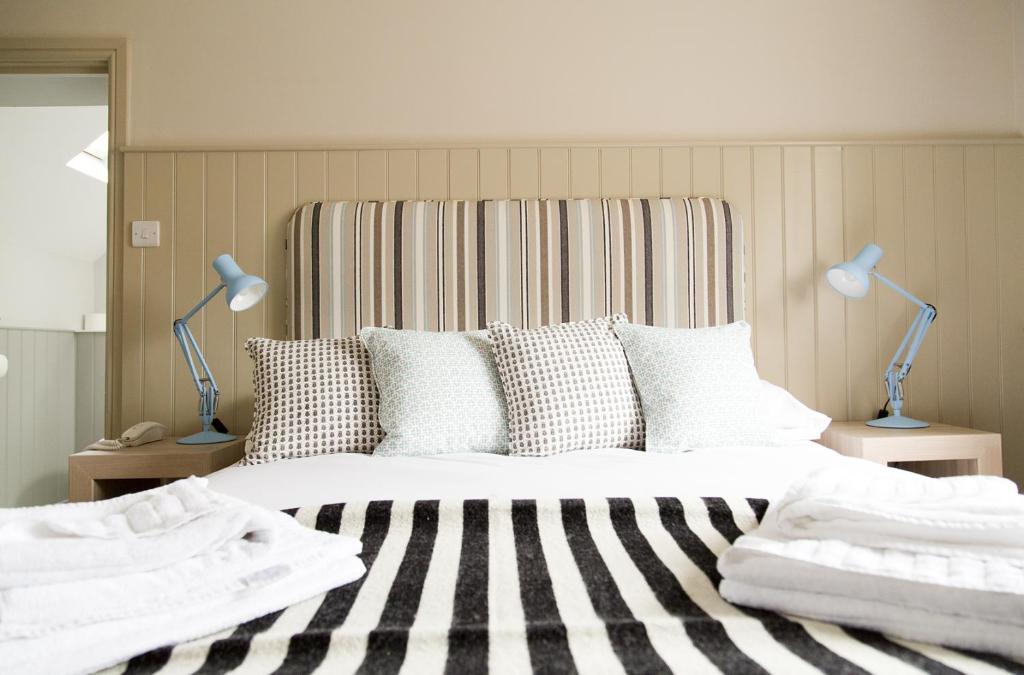 a bedroom with a large bed with two lamps at The White Horse Blakeney in Blakeney