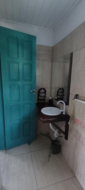 a bathroom with a blue door and a sink at Vila Pepouze Hostel in Morro de São Paulo