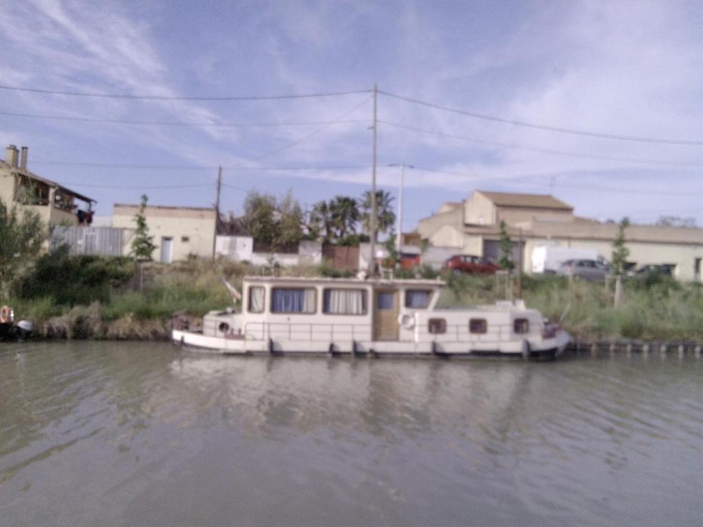 two boats docked on the water in a river at Peniche BROCOR hébergement avec participation a la navigation sur le Canal du Midi in Béziers