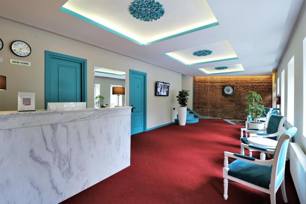 a lobby with a reception desk and red carpet at City Inn Tbilisi in Tbilisi City