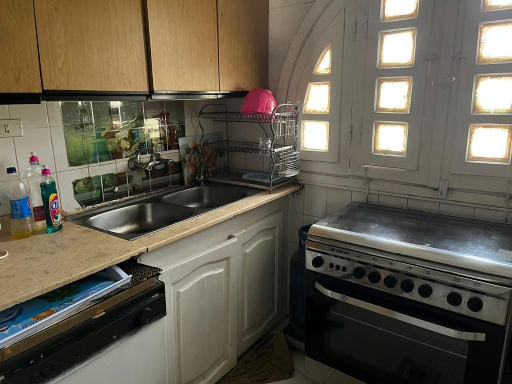 uma cozinha com um lavatório e um fogão em شاليهات للايجار بمارينا 4،5،6، em El Alamein