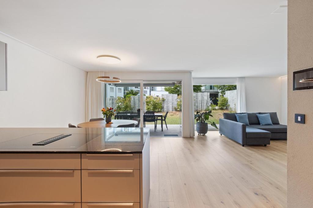 eine offene Küche und ein Wohnzimmer mit einem Sofa in der Unterkunft The R Apartment Zugerberg - EV Wallbox - Terrasse in Geroldswil