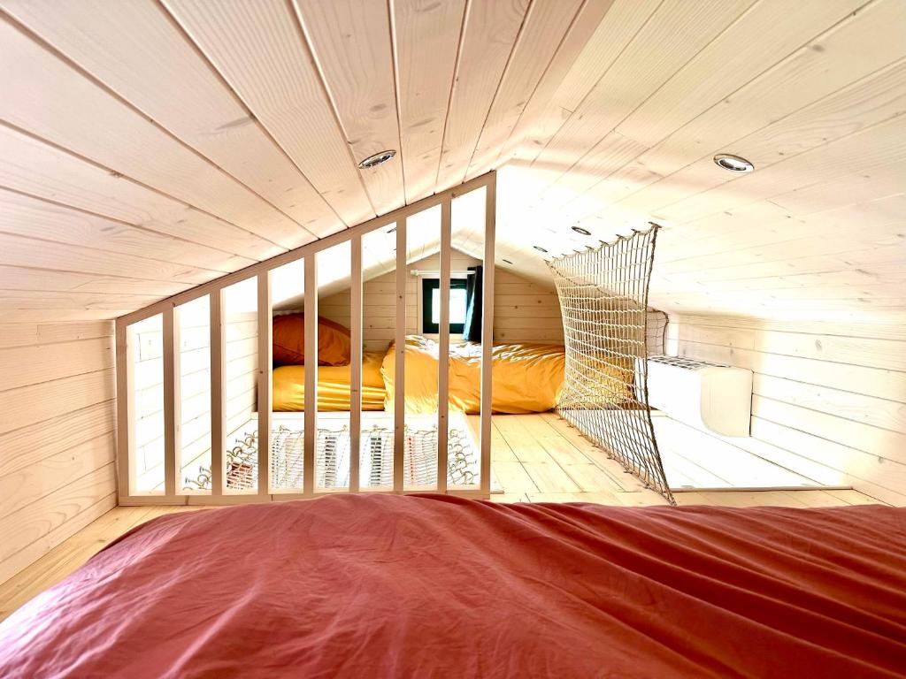 Joy Tiny House Perche في Madeleine: غرفة بسريرين بطابقين في كابينة خشبية