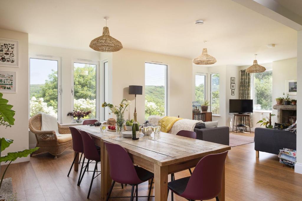 uma sala de jantar com uma mesa de madeira e cadeiras roxas em Treen House, Porthcurno em Porthcurno