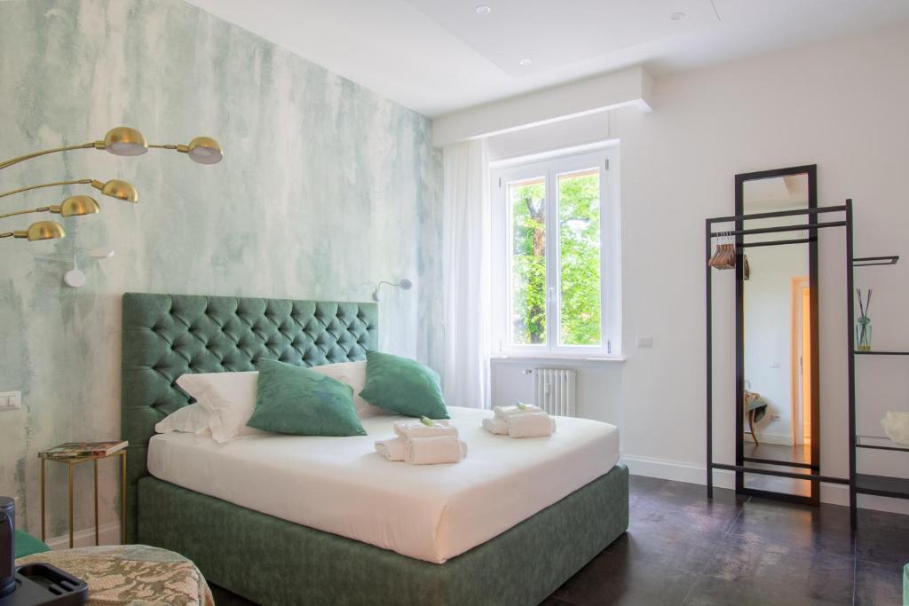 una camera con letto e testiera verde di LEOPOLDA HOME a Firenze