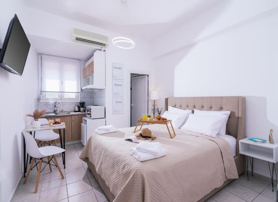 a bedroom with a large bed and a kitchen at Dreamy Delight Studio in Heraklio