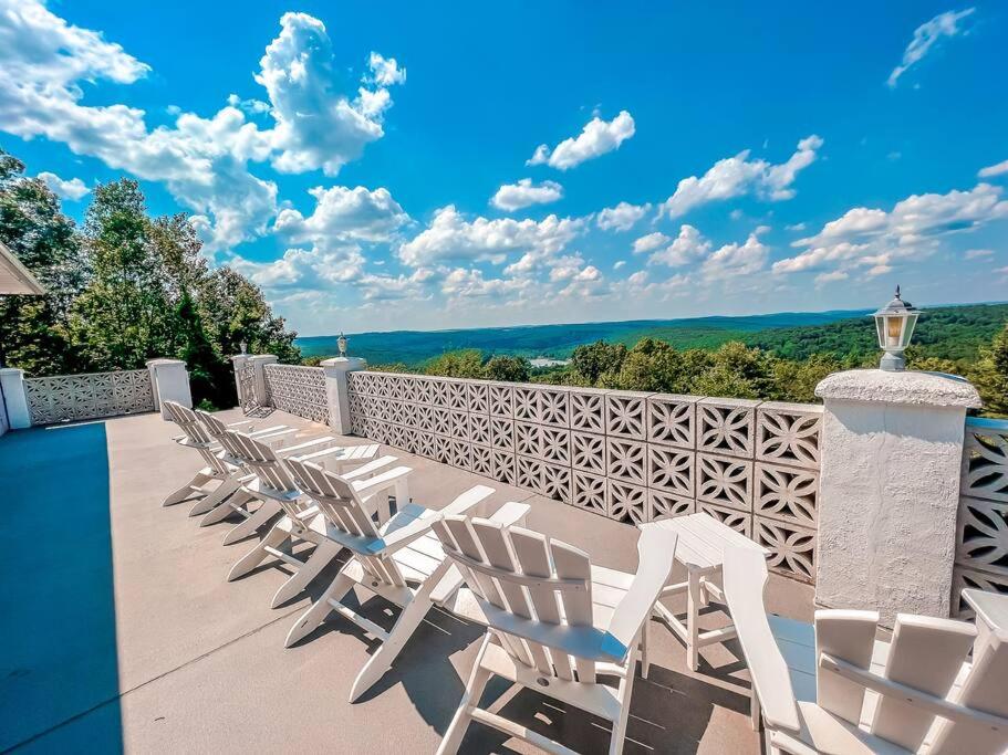 - une rangée de chaises blanches assises sur une terrasse dans l'établissement Spacious 6 Bdrm w/ Private Indoor Pool + VIEWS, à Narrowsburg